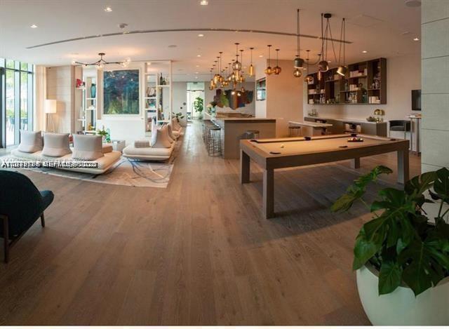 480 Northeast 31st Street, Unit 902 Miami, FL 33137 - Photo 25 of 33 a living room with lots of furniture and a chandelier