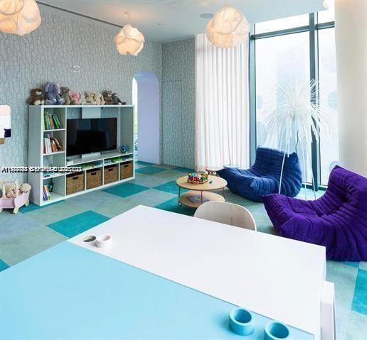 480 Northeast 31st Street, Unit 902 Miami, FL 33137 - Photo 33 of 33 a living room with furniture and a flat screen tv