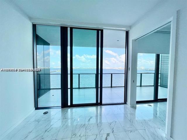 480 Northeast 31st Street, Unit 902 Miami, FL 33137 - Photo 10 of 33 an empty room with sliding glass door and door