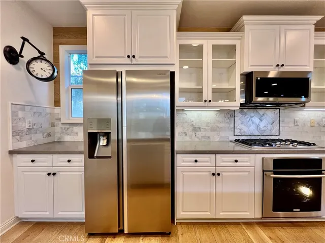 a kitchen with white cabinets and stainless steel appliances