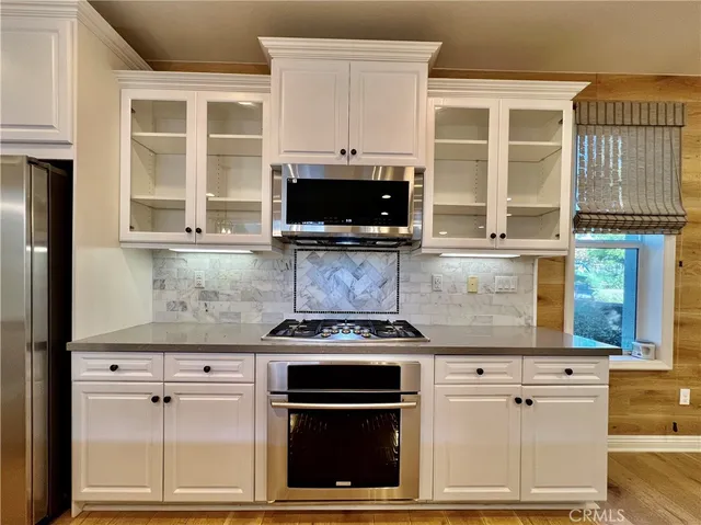 a kitchen with stainless steel appliances granite countertop a stove and a microwave
