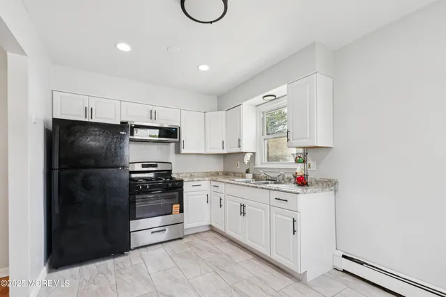 a kitchen with a refrigerator sink and cabinets