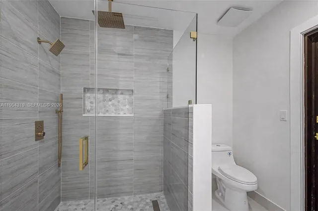 a bathroom with a toilet and a shower