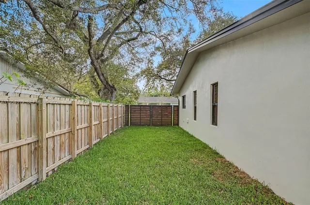 a view of a backyard with wooden fence