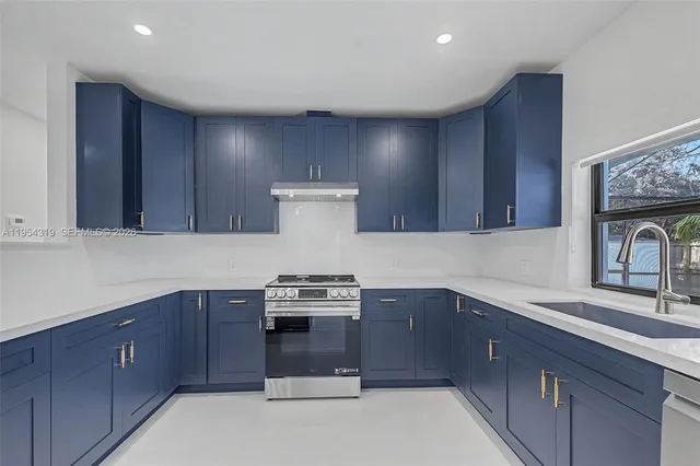 a kitchen with sink a stove and cabinets