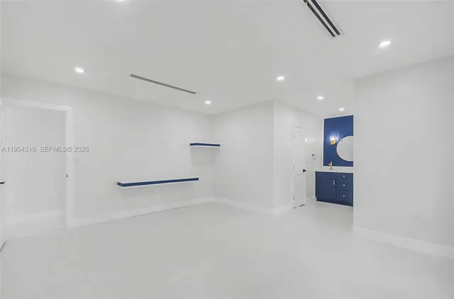 an empty room with entrance and wooden floor