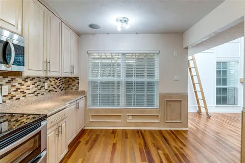 a view of a kitchen with wooden floor and windows