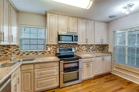 a kitchen with granite countertop a stove sink and cabinets
