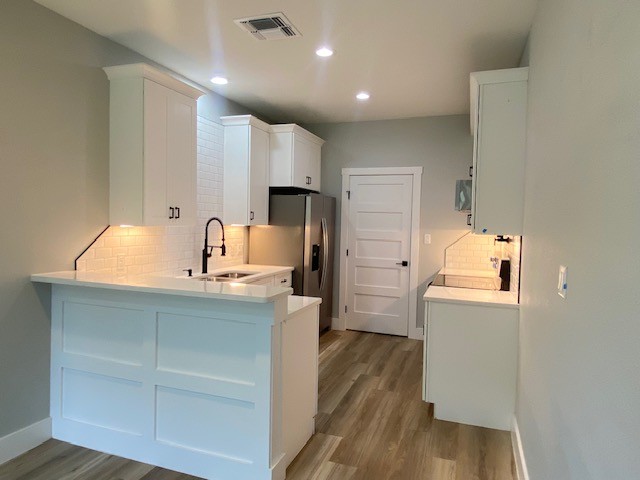 116 Field Street Luling, TX 78648 - Photo 27 of 33 Modern kitchen featuring sleek white cabinetry, a convenient breakfast bar, and new stainless steel appliances.
