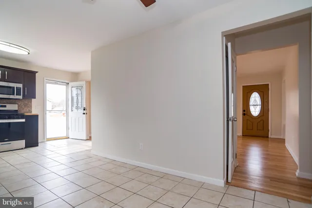 a view of a hallway with wooden floor and a living room