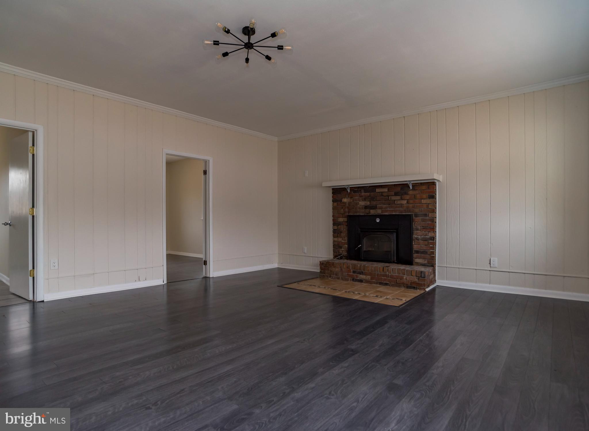 2427 Buttonwood Lane Millville, NJ 08332 - Photo 13 of 58 a view of an empty room with wooden floor and a fireplace