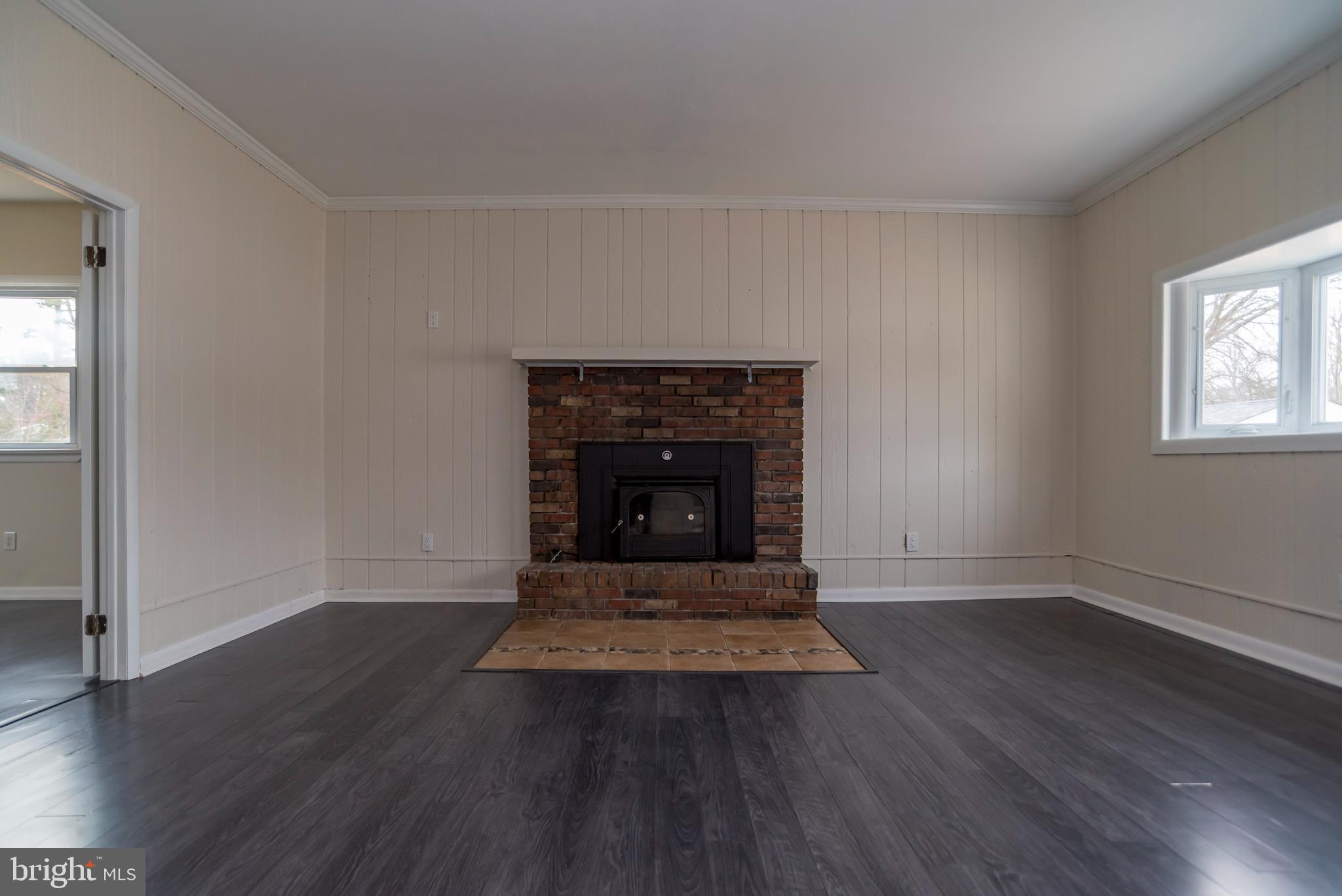 2427 Buttonwood Lane Millville, NJ 08332 - Photo 15 of 58 an empty room with wooden floor and a fireplace