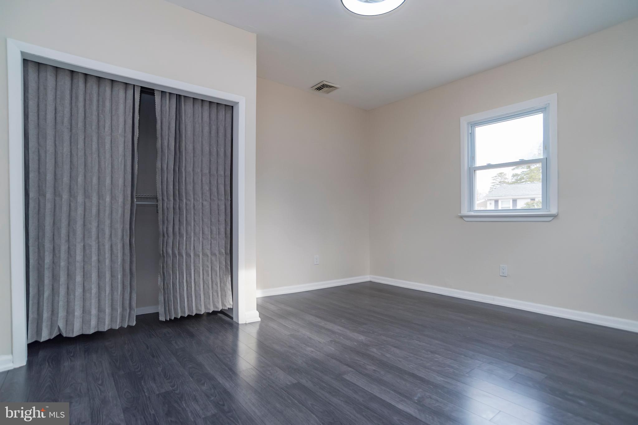 2427 Buttonwood Lane Millville, NJ 08332 - Photo 21 of 58 an empty room with wooden floor and windows