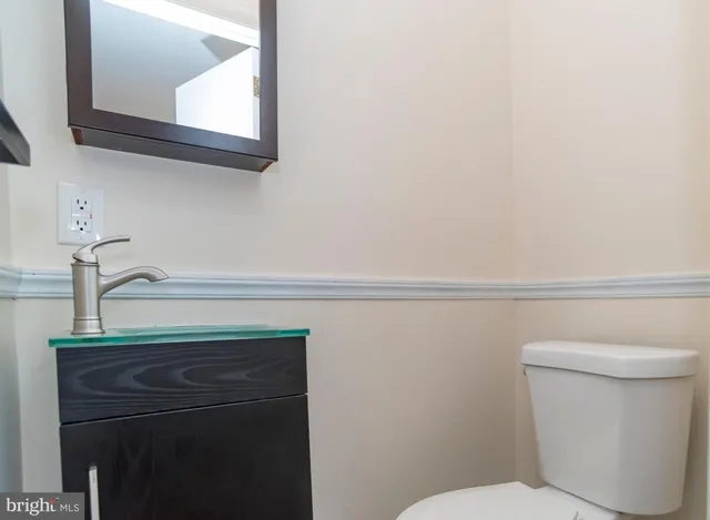 a bathroom with a toilet a sink and vanity