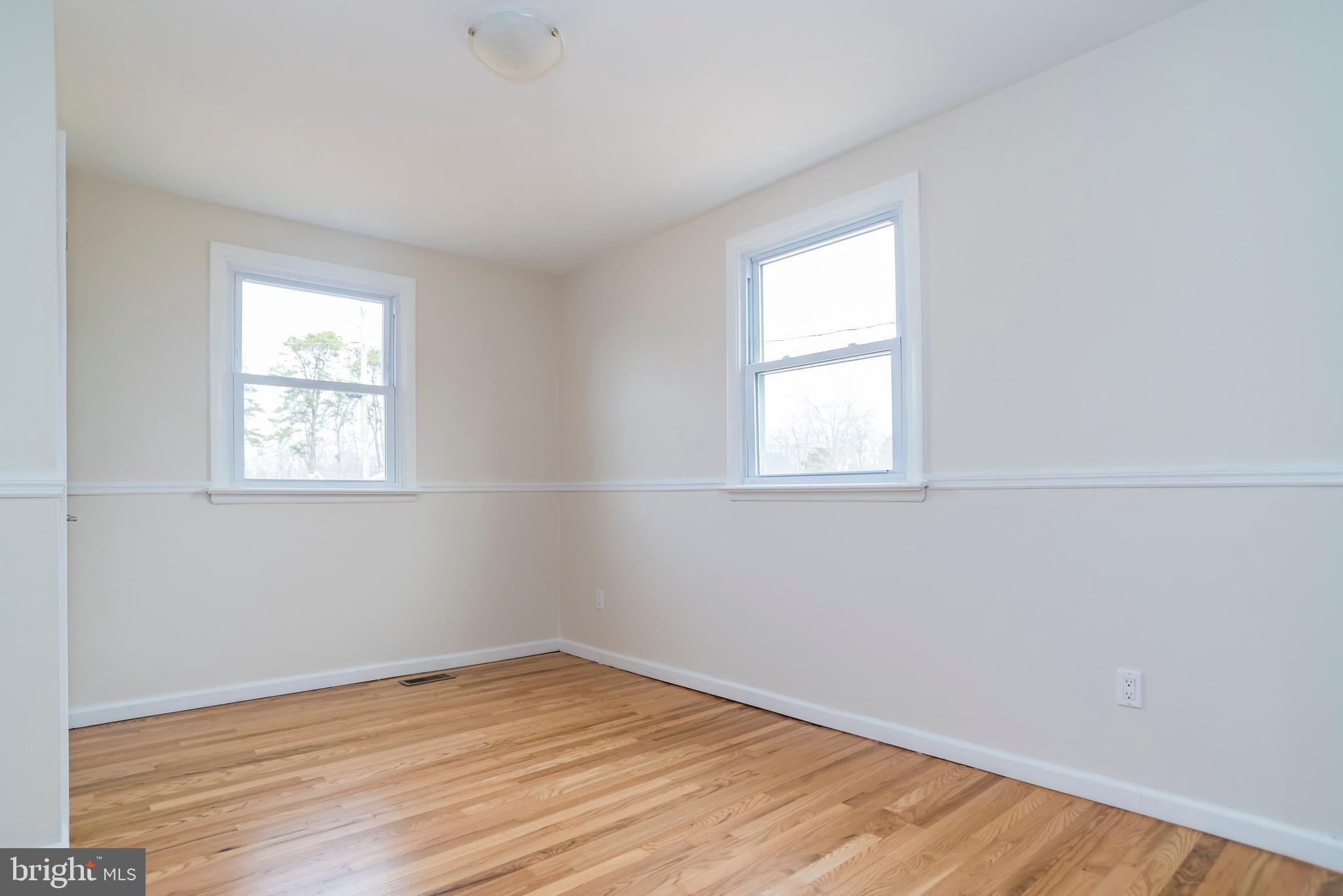 2427 Buttonwood Lane Millville, NJ 08332 - Photo 39 of 58 an empty room with wooden floor and windows