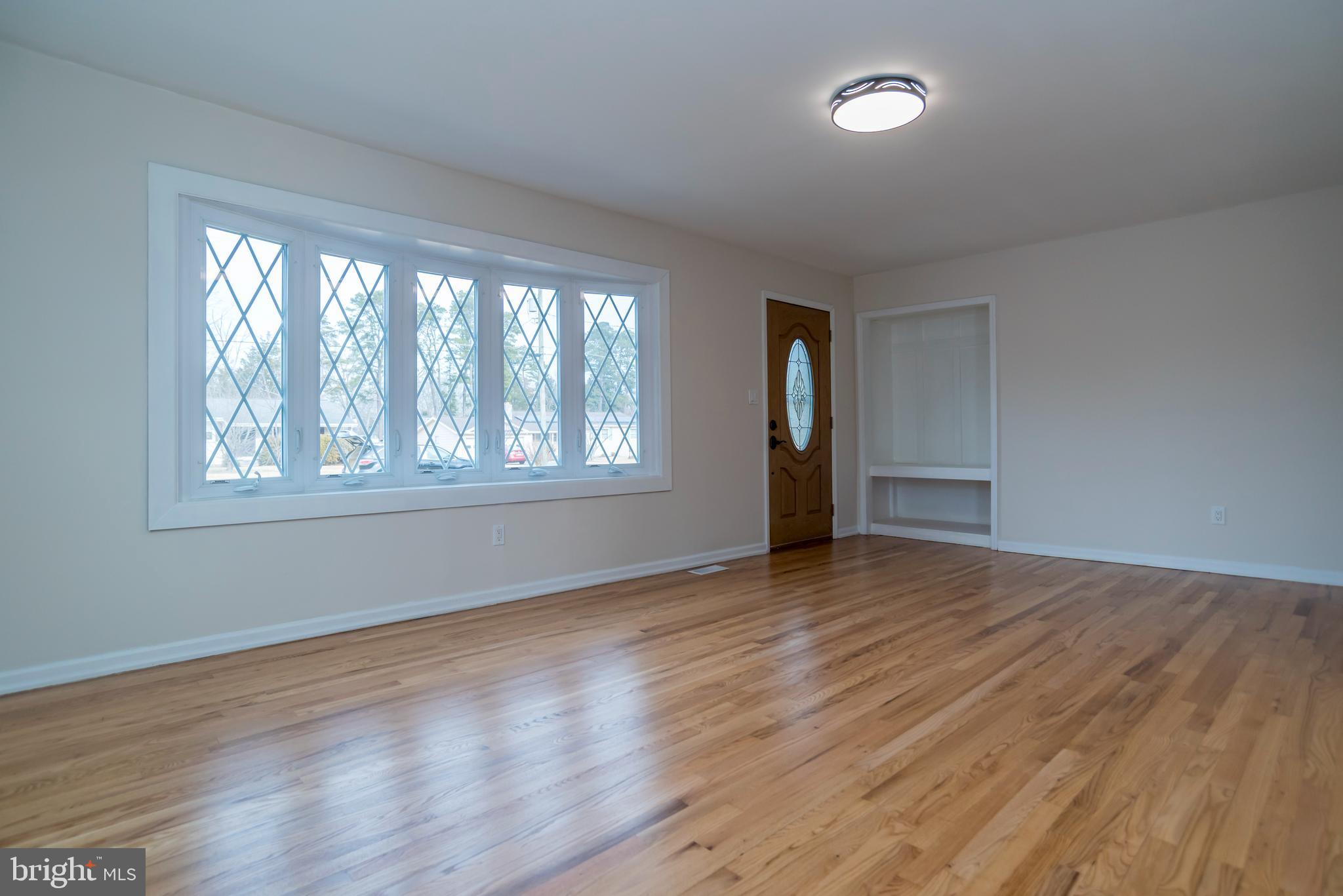 2427 Buttonwood Lane Millville, NJ 08332 - Photo 5 of 58 a view of an empty room with wooden floor and a window