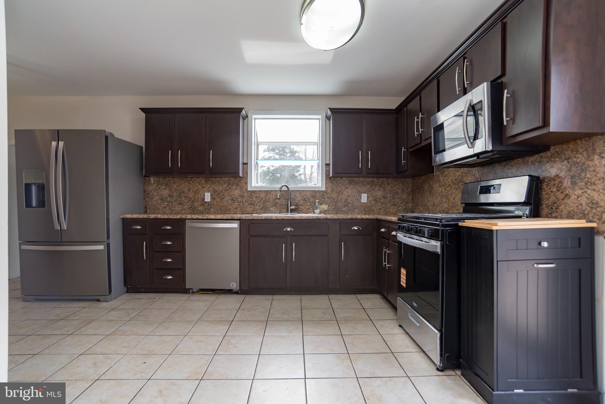 2427 Buttonwood Lane Millville, NJ 08332 - Photo 9 of 58 a kitchen with stainless steel appliances granite countertop a stove a sink and a refrigerator
