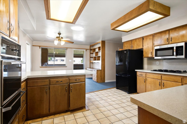 2252 West 800 North Clinton, UT 84015 - Photo 12 of 38 Kitchen featuring wood cabinetry, light-toned countertops, tile flooring, and stainless steel appliances
