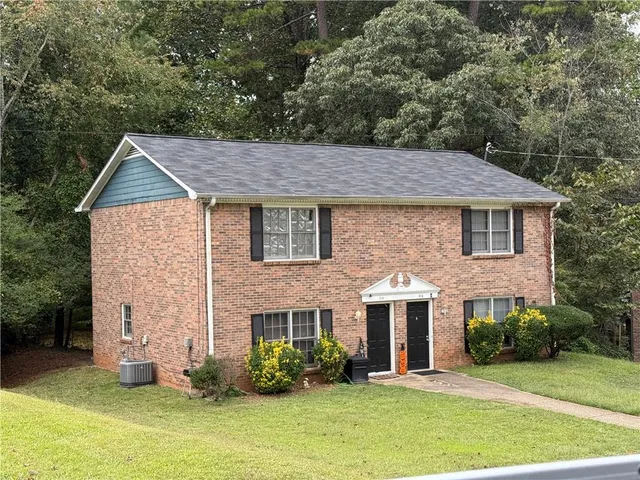 a front view of a house with a garden and plants