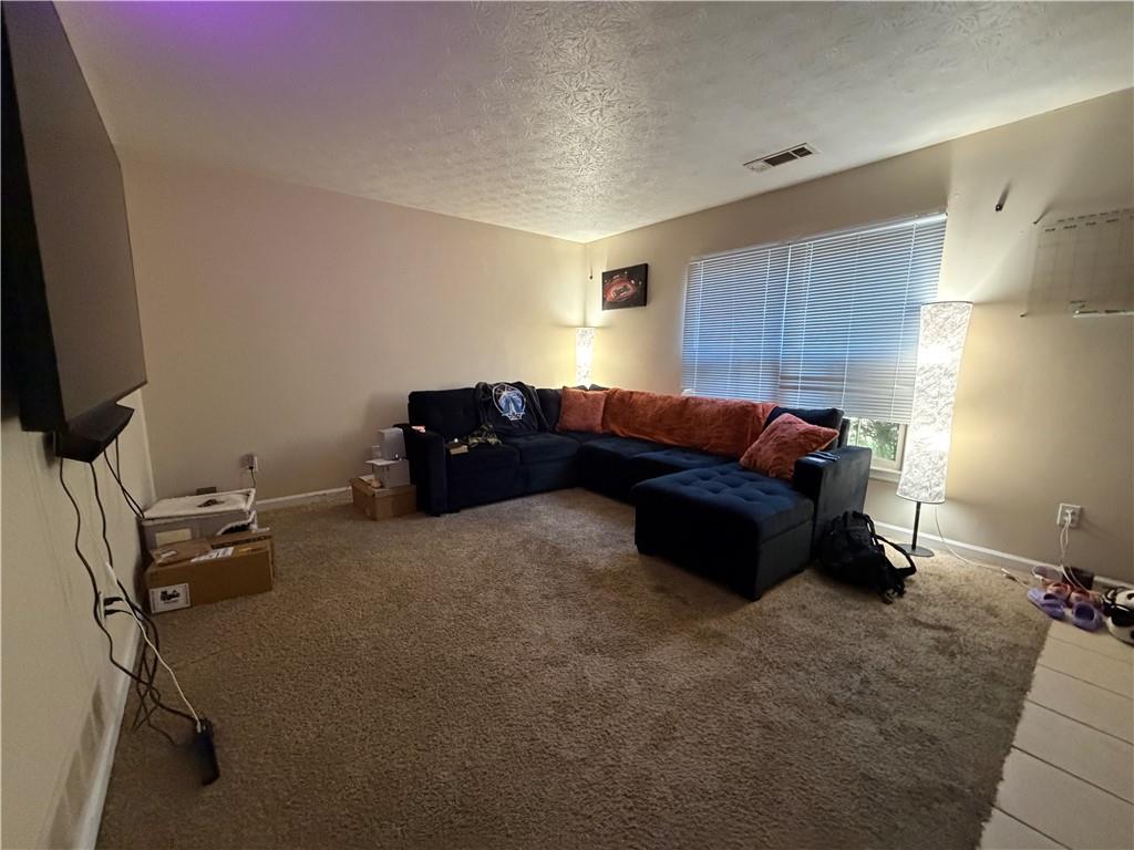 310 Bedford Bay Lane Lawrenceville, GA 30046 - Photo 6 of 23 a living room with a couch and a flat screen tv