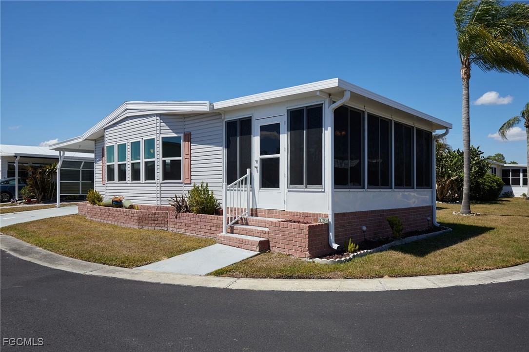 15 Ilex Street Alva, FL 33920 - Photo 2 of 43 a front view of a house with a yard and porch
