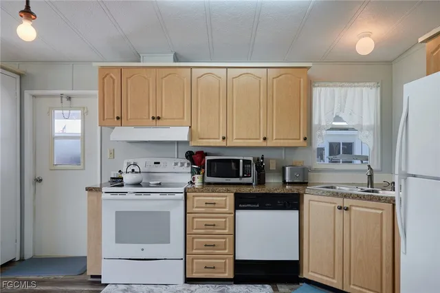a kitchen with cabinets appliances and a sink