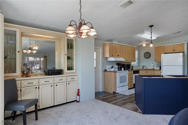 a open kitchen with stainless steel appliances granite countertop a sink dishwasher a stove and a refrigerator with wooden floor