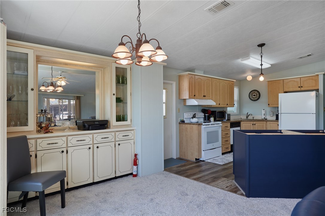 15 Ilex Street Alva, FL 33920 - Photo 8 of 43 a open kitchen with stainless steel appliances granite countertop a sink dishwasher a stove and a refrigerator with wooden floor