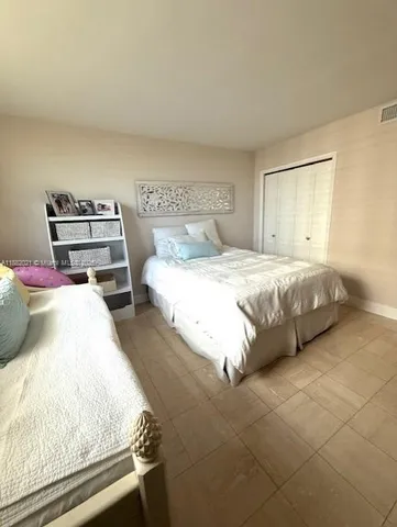 a large white kitchen with a large window and stainless steel appliances