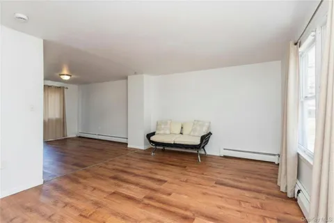 a view of a room with wooden floor and lounge chair