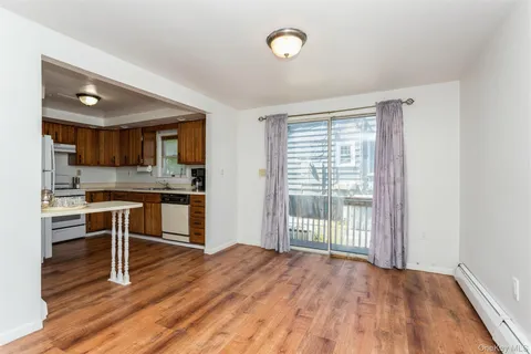 a open kitchen with granite countertop a stove top oven a sink and a wooden floors