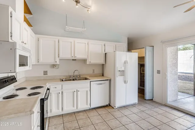 a kitchen with white cabinets and white appliances