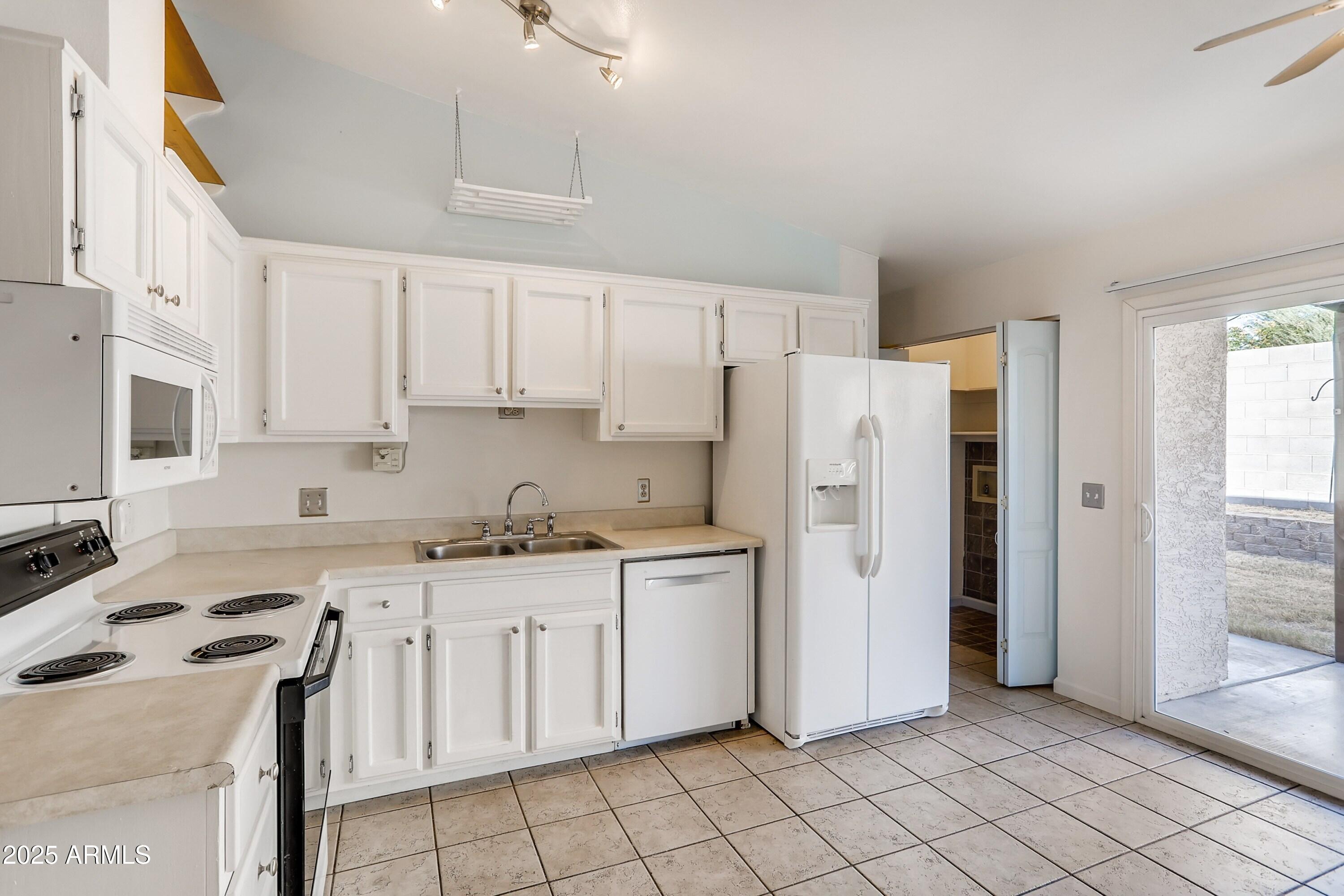 510 East Sequoia Drive Phoenix, AZ 85024 - Photo 3 of 12 a kitchen with white cabinets and white appliances
