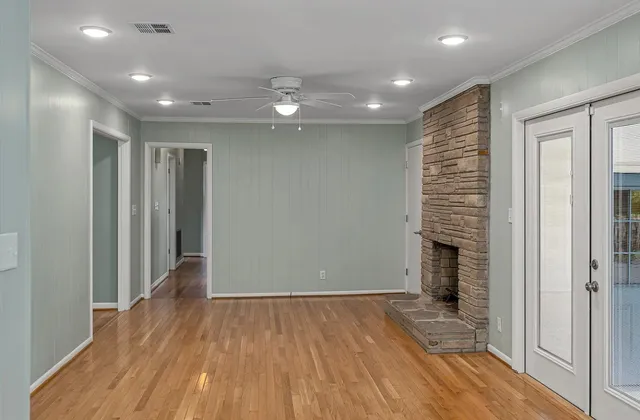 a view of empty room with wooden floor and fireplace