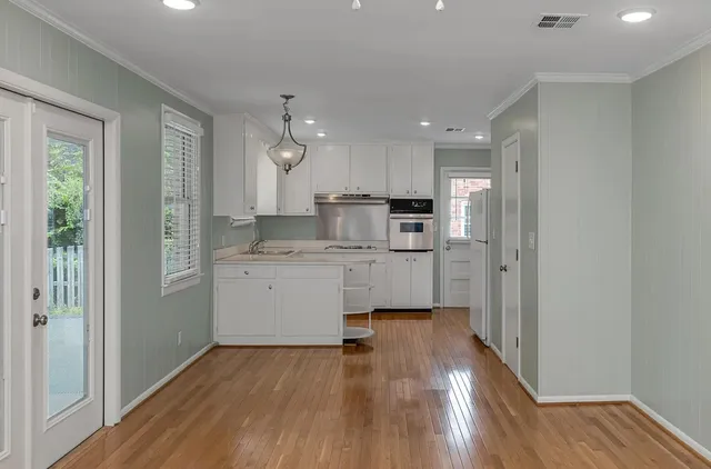 a kitchen with a refrigerator a sink and wooden floor
