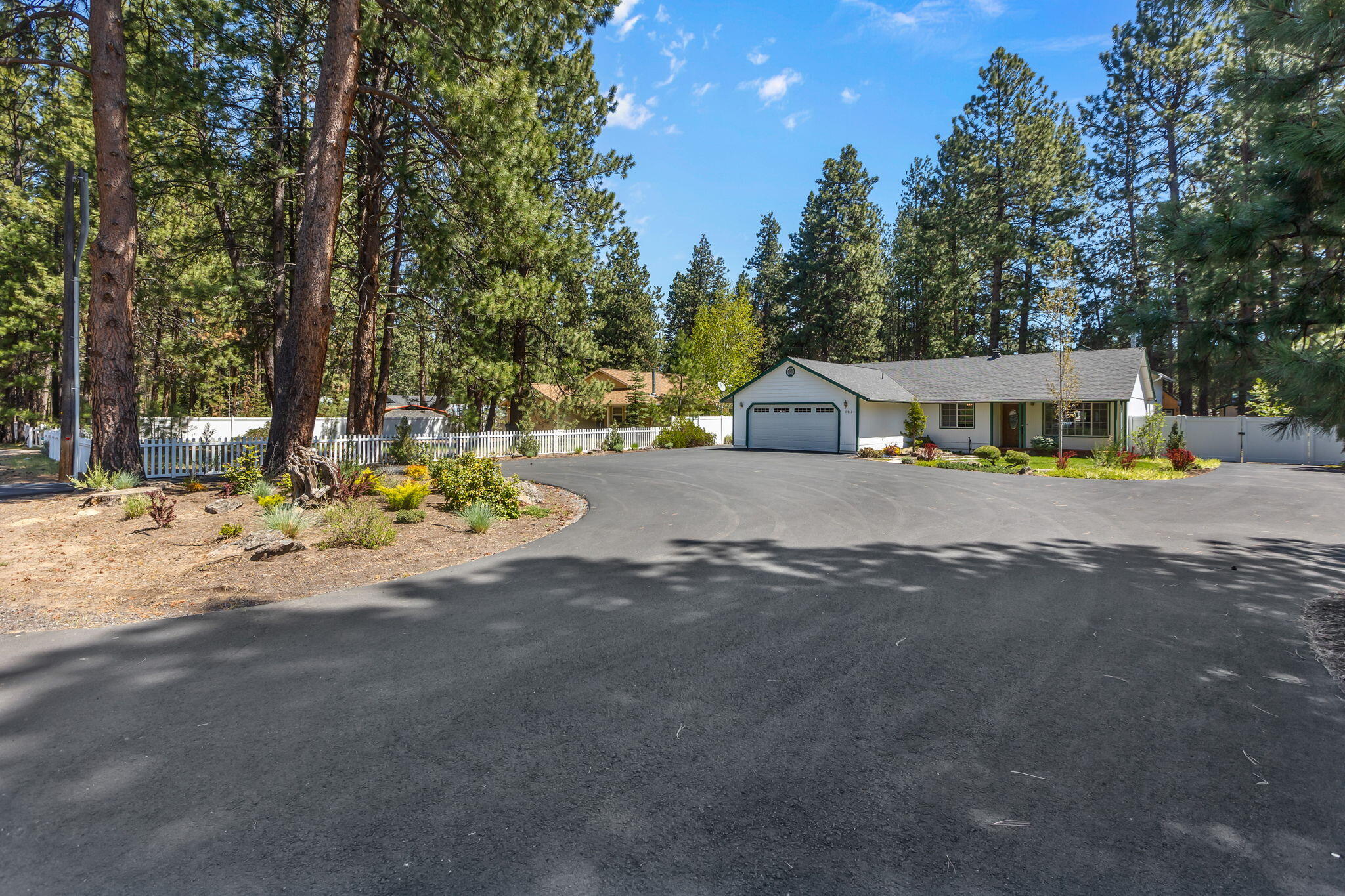 59842 Navajo Road Bend, OR 97702 - Photo 3 of 52 a view of a white house with a big yard and large trees