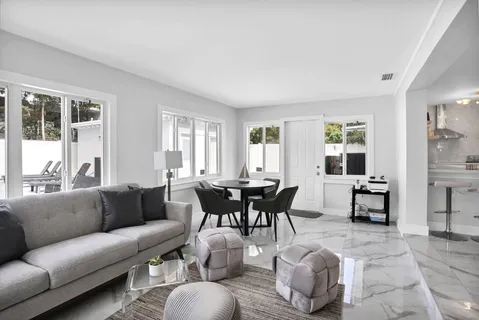 a living room with furniture and large windows