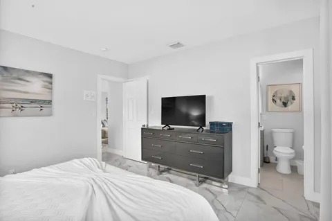 a bedroom with a bed and a flat screen tv