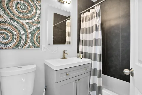 a bathroom with a sink a toilet and shower