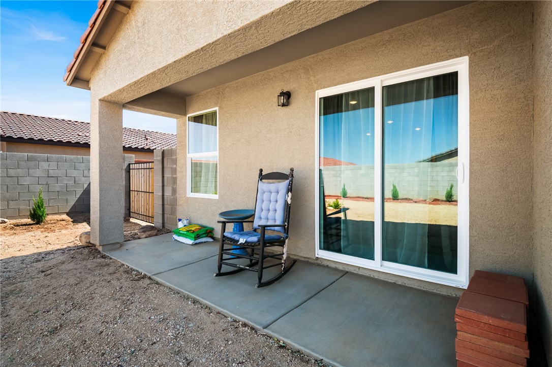3623 East Andrea Drive Kingman, AZ 86409 - Photo 36 of 40 The property features a covered patio with a concrete slab, a sliding glass door, and an exterior light fixture