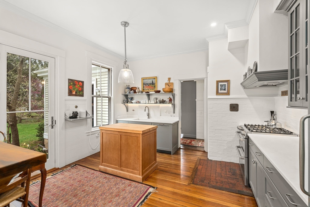 135 Court Street Dedham, MA 02026 - Photo 15 of 40 a kitchen with stainless steel appliances granite countertop a refrigerator a sink dishwasher a dining table and chairs with wooden floor