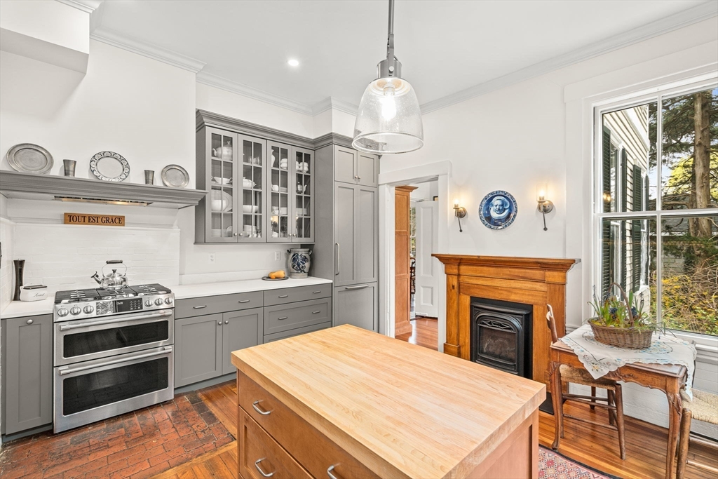 135 Court Street Dedham, MA 02026 - Photo 16 of 40 a kitchen with a stove and a fireplace