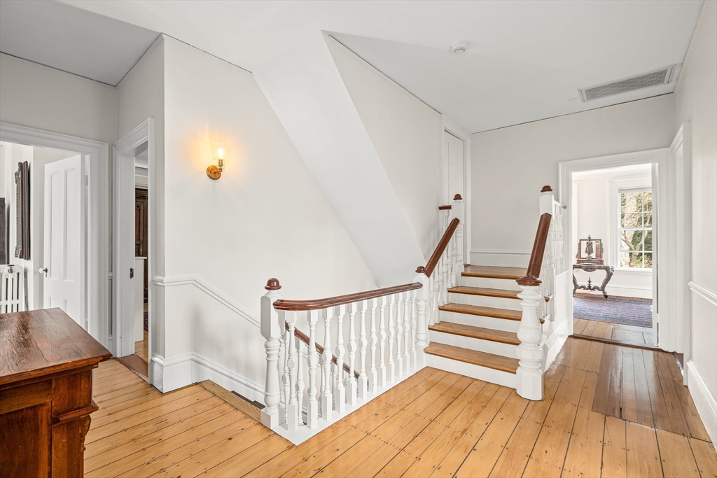 135 Court Street Dedham, MA 02026 - Photo 20 of 40 a view of a hallway with wooden floor and staircase