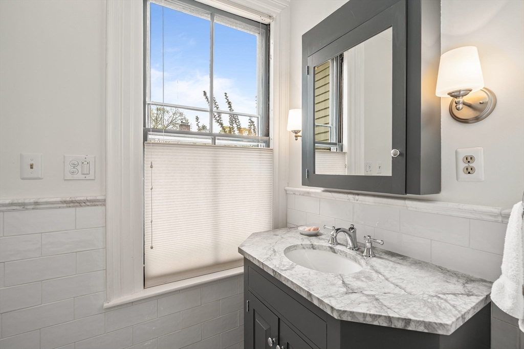 135 Court Street Dedham, MA 02026 - Photo 25 of 40 a bathroom with a granite countertop sink and a mirror