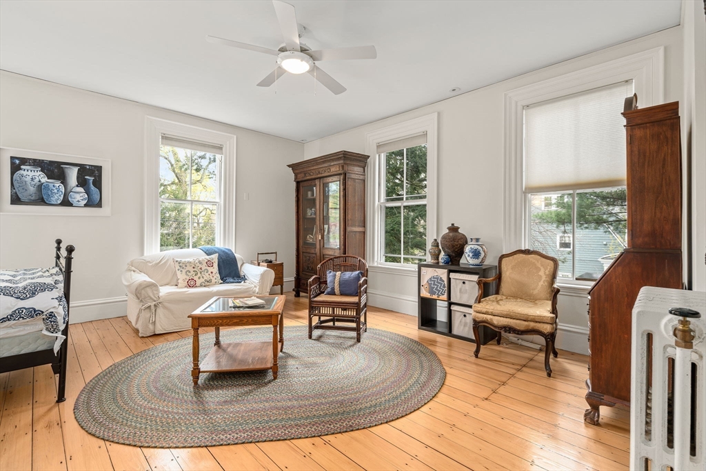 135 Court Street Dedham, MA 02026 - Photo 29 of 40 a living room with couches a coffee table and a piano table with wooden floor