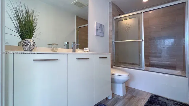 a bathroom with a sink a toilet and shower