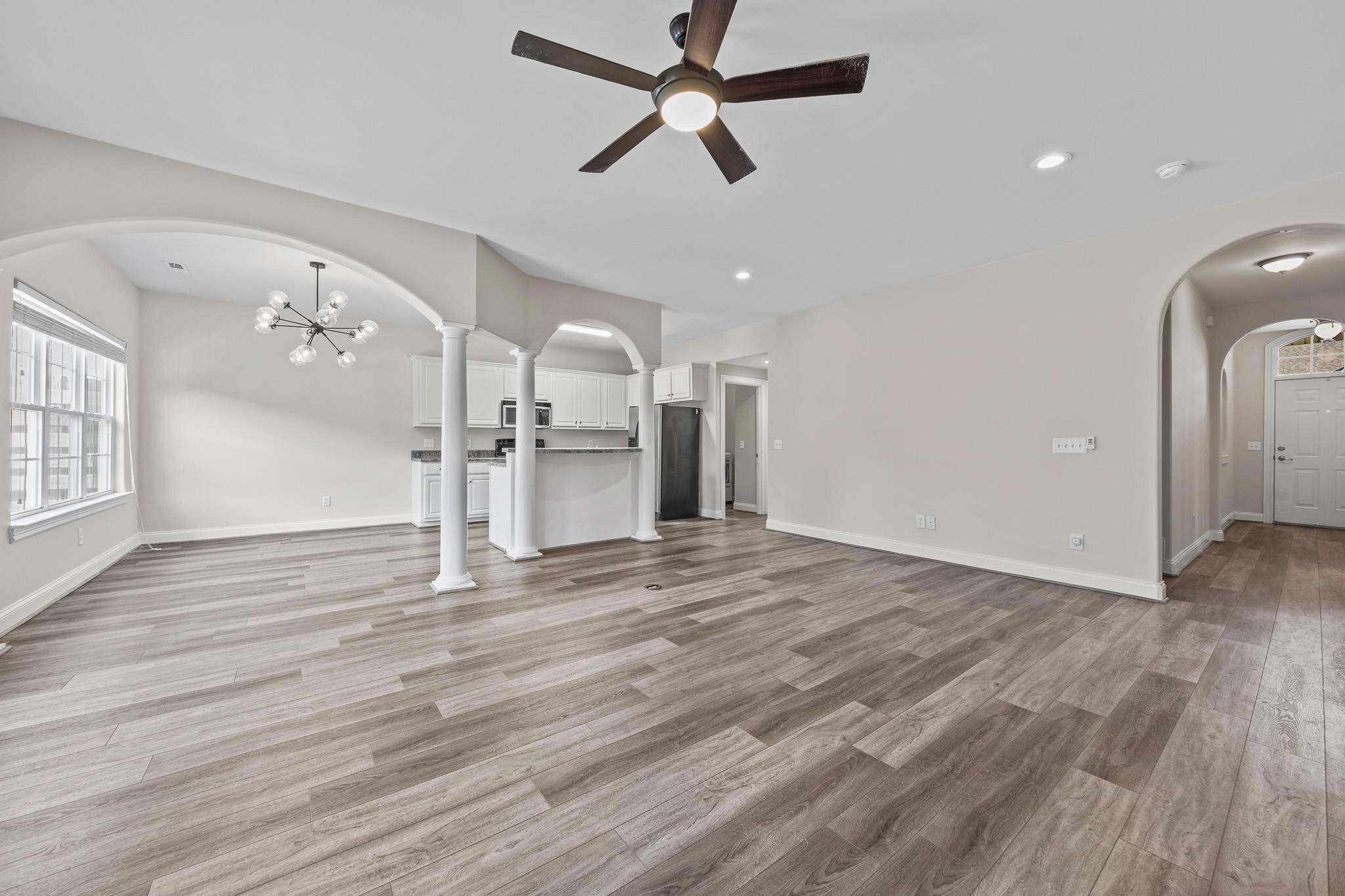 2521 Pennington Bend Road, Unit 119 Nashville, TN 37214 - Photo 11 of 47 an empty room with wooden floor a ceiling fan and kitchen view