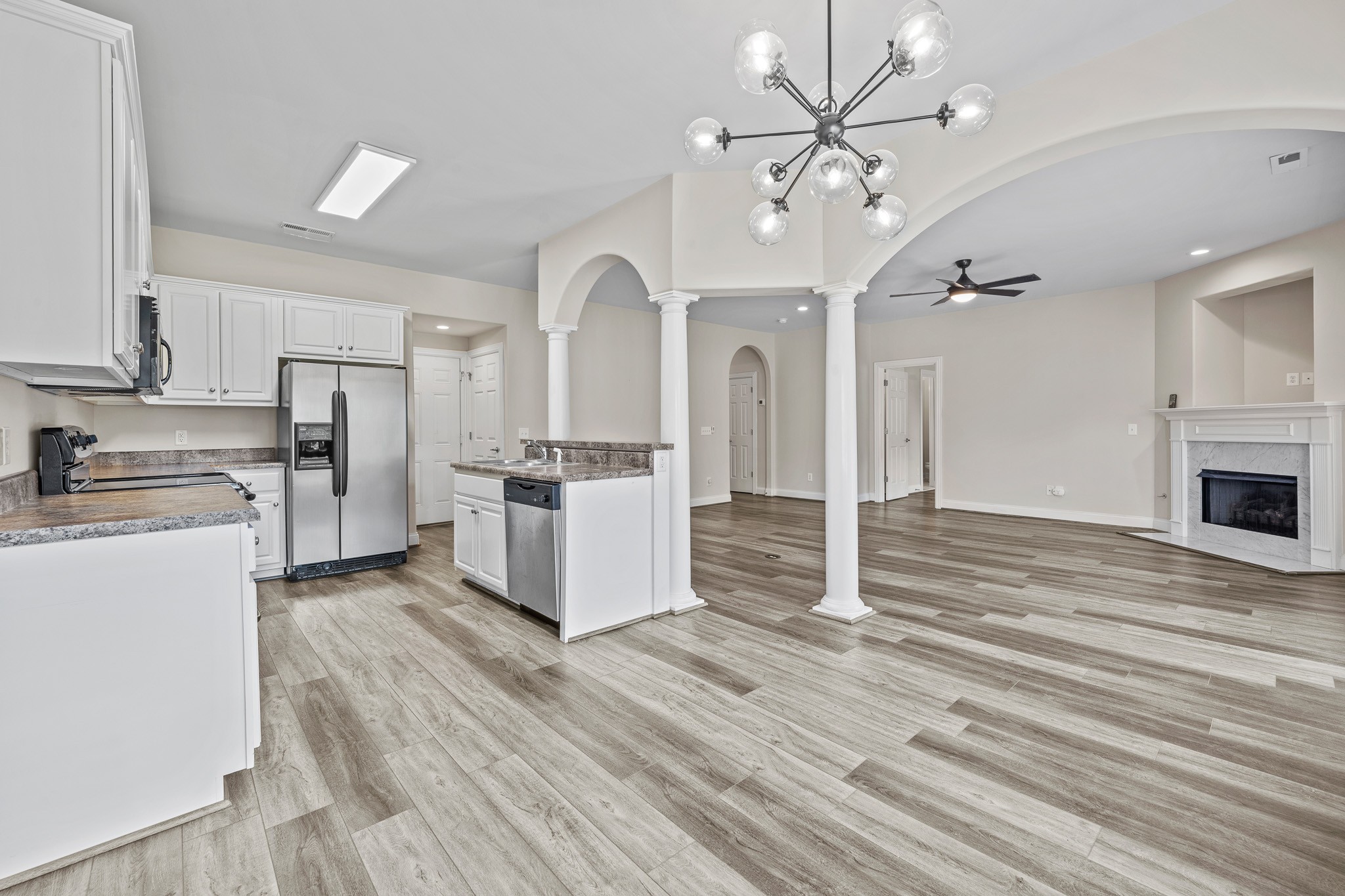 2521 Pennington Bend Road, Unit 119 Nashville, TN 37214 - Photo 12 of 47 a kitchen with stainless steel appliances kitchen island wooden floors and white cabinets