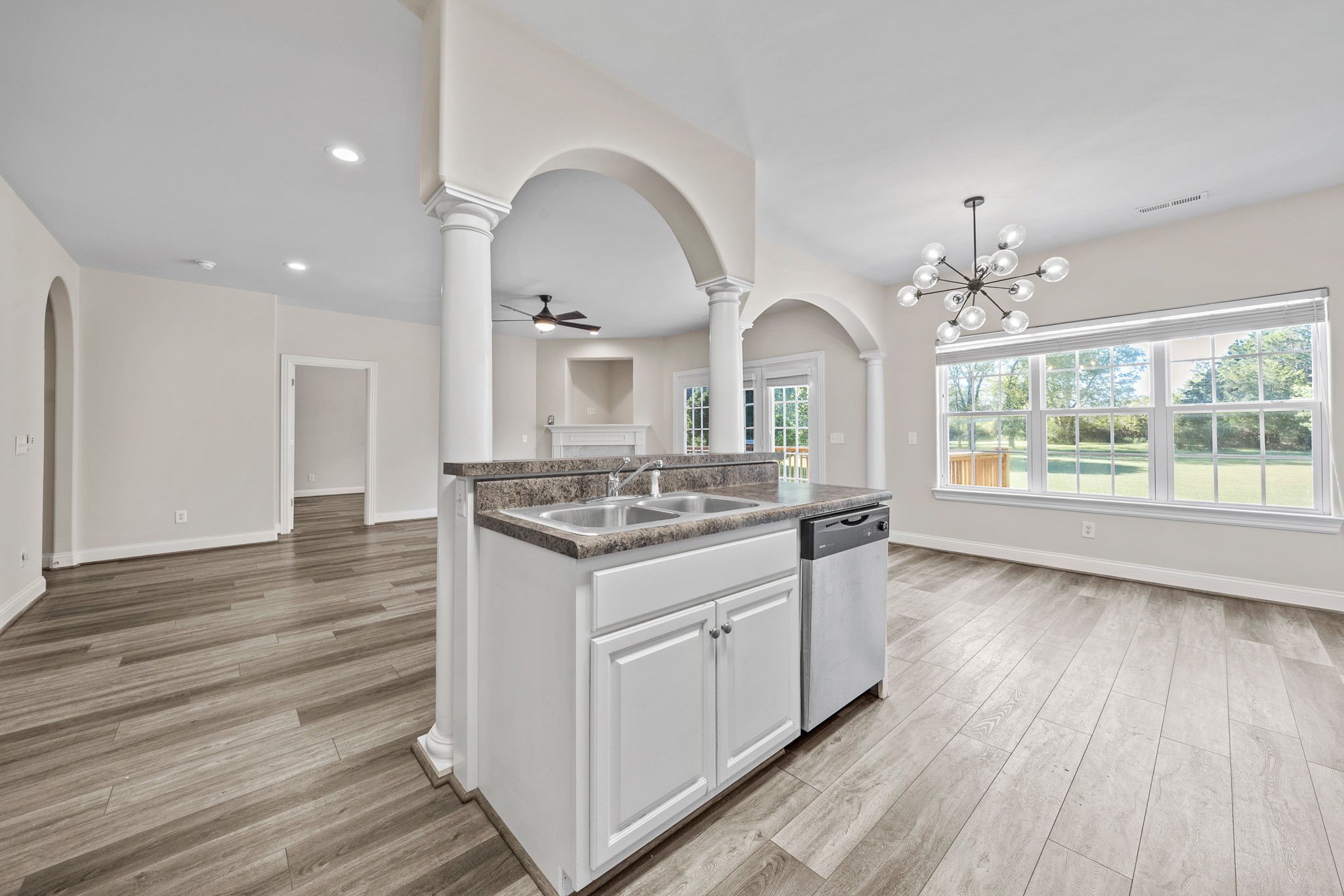 2521 Pennington Bend Road, Unit 119 Nashville, TN 37214 - Photo 17 of 47 a hall with kitchen island a stove a wooden floor and a large window