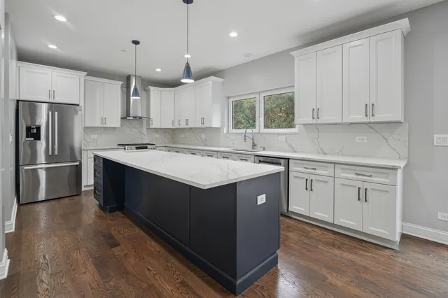 a kitchen with a sink window and stainless steel appliances
